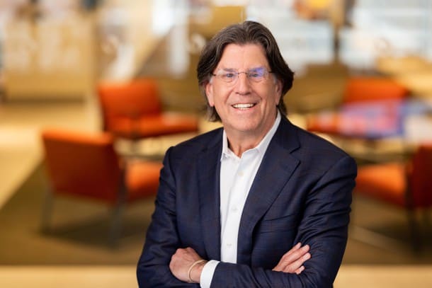 Mark L. Alderman with arms folded, smiling